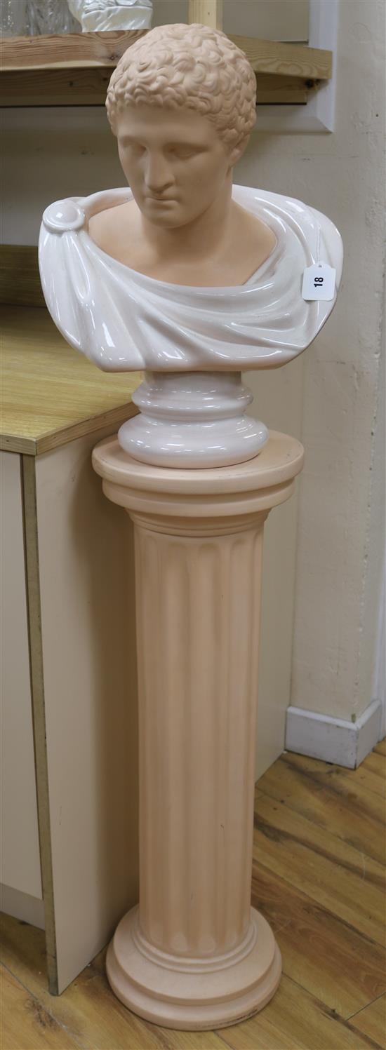 A terracotta and white marble effect bust of a Roman Emperor, raised on a plinth